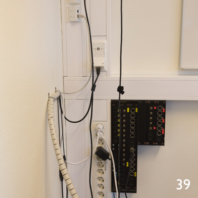 Tilkoblingspunkter ved siden av talerstol i rommet.
